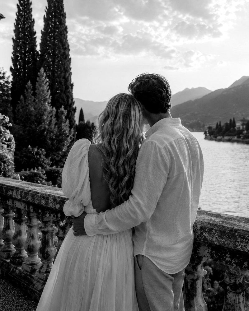 Black-and-white photo of a couple looking out over Lake Como